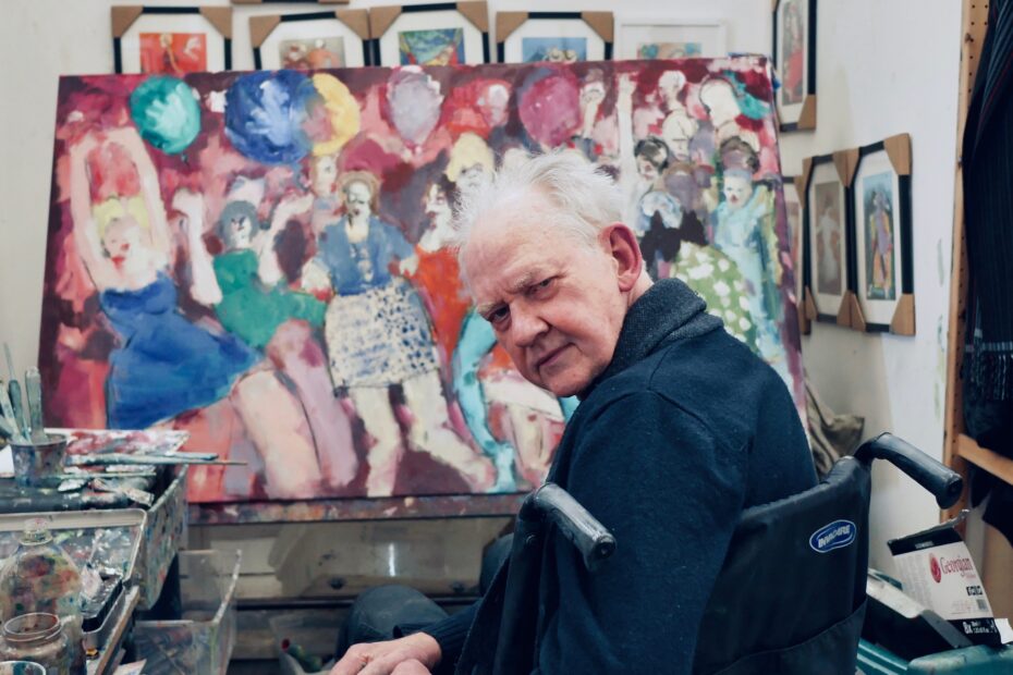 Peter Cameron pictures in front of his art